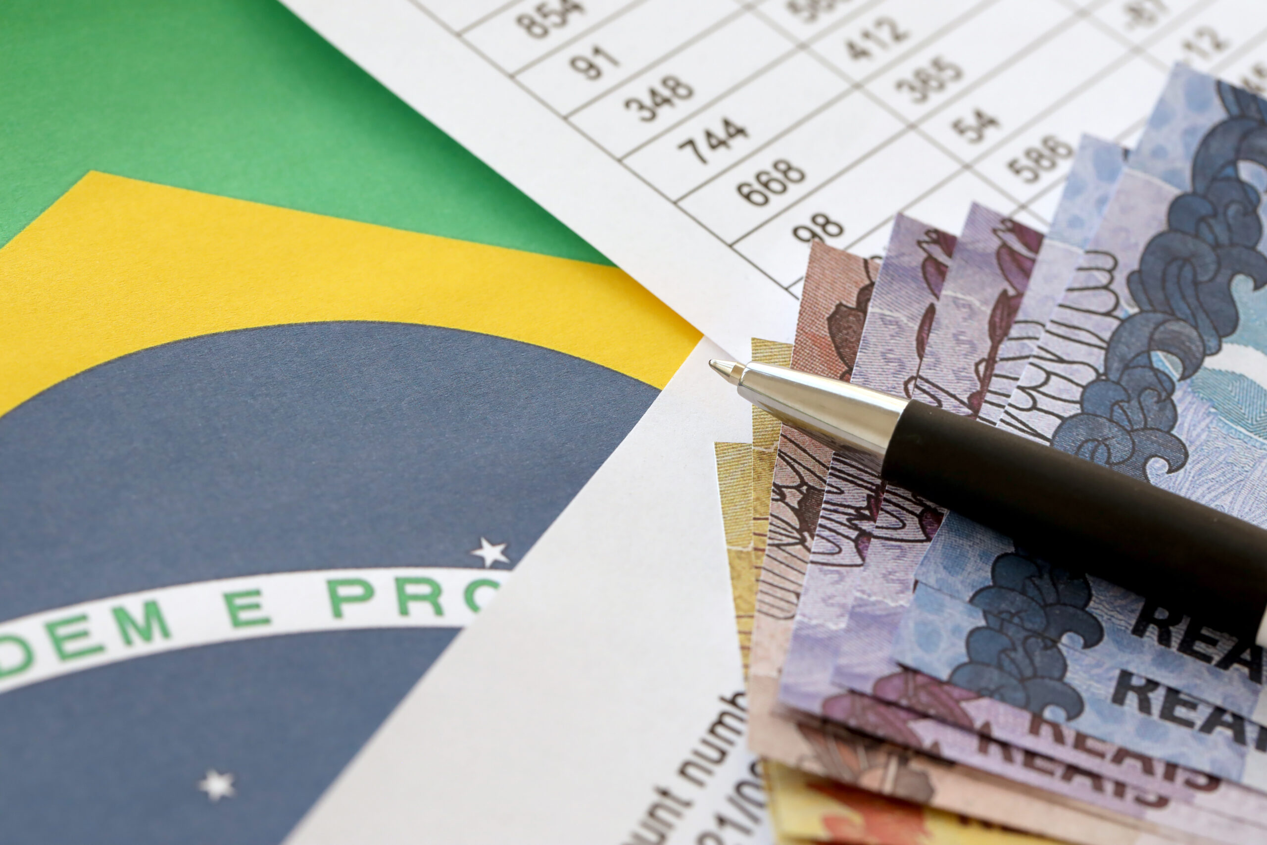 Pen With Brazilian Money Bills On Blank Of Lottery Game. Concept Of Luck And Gambling In Brazil - CONTEL Consultoria Contábil e Empresarial